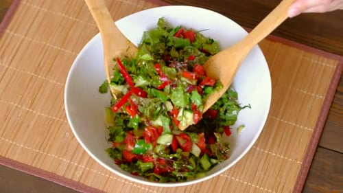 Woman Stirring A Bowl Of Fresh Vegetable Salad