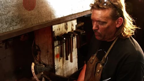 Blacksmith heating a horseshoe in fire