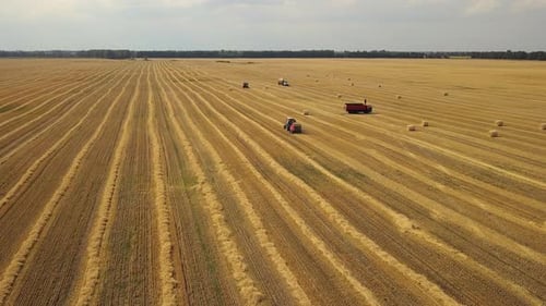 Aerial footage: Farm machines at work in agriculture field.