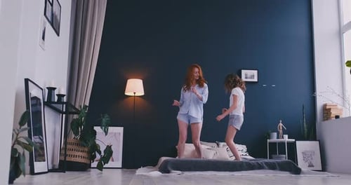 Mother and Child Dancing on Bed Together