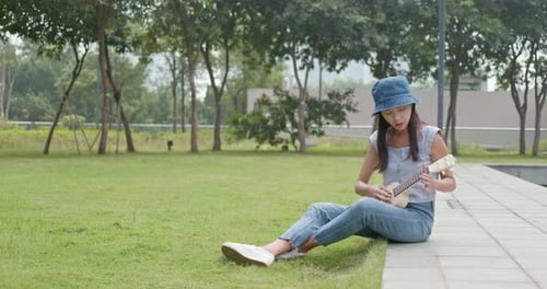 Woman playing ukulele at city