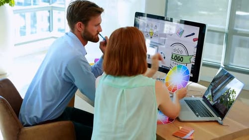 Graphic Designers Collaborating on a Logo in Bright Office