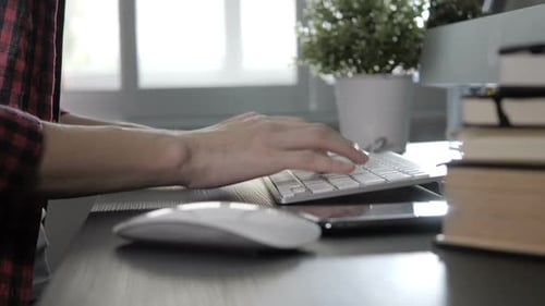 Hands Typing on a Keyboard in Home Office