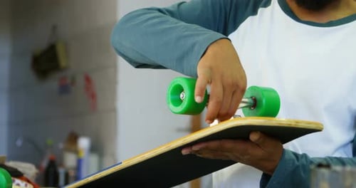 Man Assembling a Skateboard Wheel Indoors