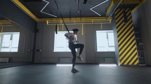 Sporty Woman Doing TRX Exercises in the Gym