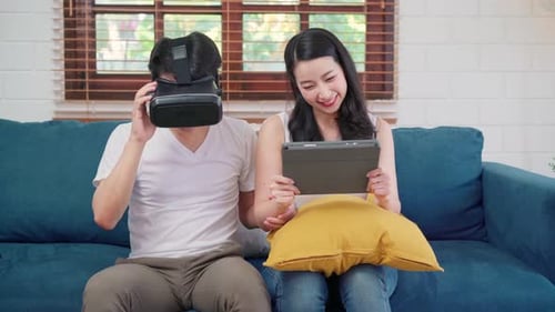 Couple Laughing Using VR and Tablet at Home