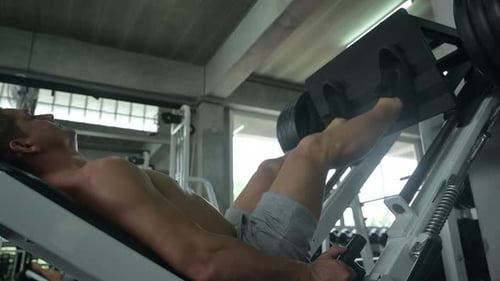 Athletic man exercises in gym fitness for strength training and bodybuilding workout
