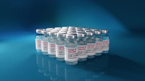 COVID-19 Vaccine Vials Dolly In on Blue Background