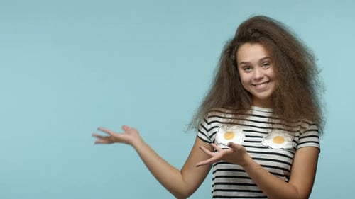 Happy Woman Gesturing to Copy Space on Blue
