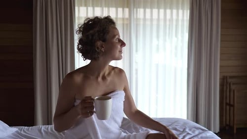 Woman Sitting in Bed With Coffee