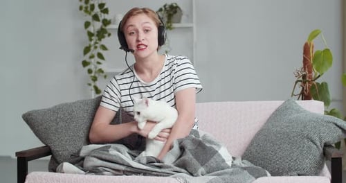 Webcam View Caucasian Woman in Headphones Says Hugging Cat. Girl Mentor Teacher Psychologist Student