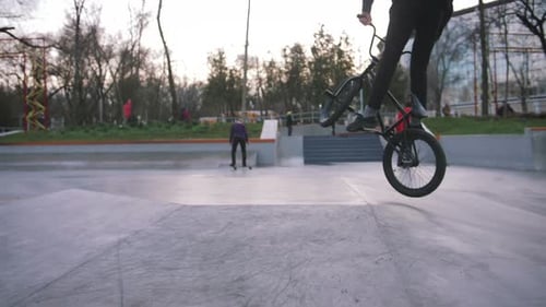 BMX Rider Doing Tricks in Street Plaza Bicycle Stunt Rider in Cocncrete Skatepark Super Slow Motion