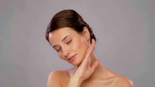 Woman Smiles While Posing and Touching Her Neck