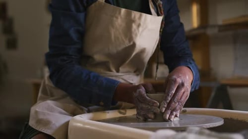 Section centrale d'une potière créant de la poterie sur une roue de potier dans un atelier de poterie