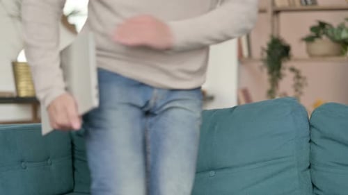 Man Finishes Working and Closes Laptop on Couch