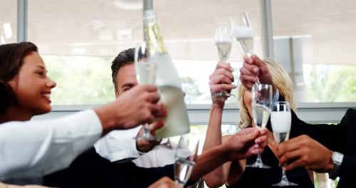 Grupo de amigos sorridentes brindando taça de champanhe