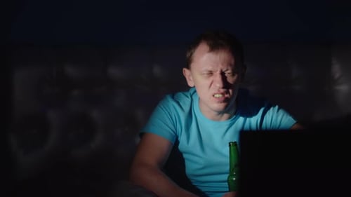 Man Drinking at Night Watching Screen at Home