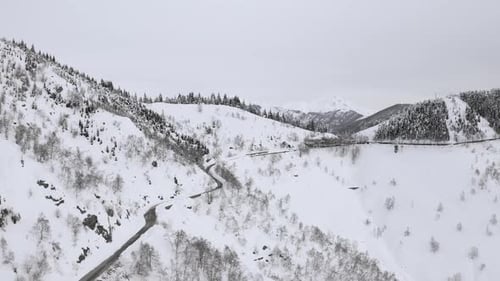 Aerial View of Snow Capped Mountain Range Landscape in Winter During Sunset