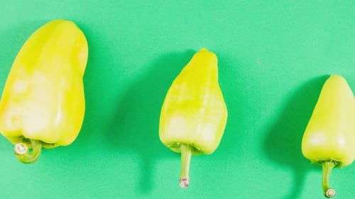 Fresh Yellow Peppers on Green Background