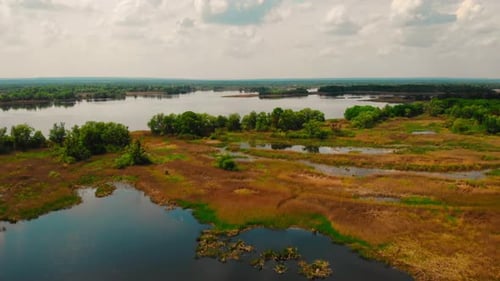Drone Flying Above River with Piece of Land