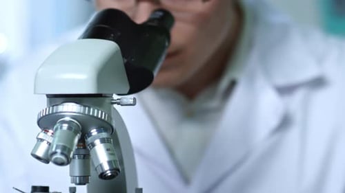 Scientist Using Microscope in Laboratory for Research