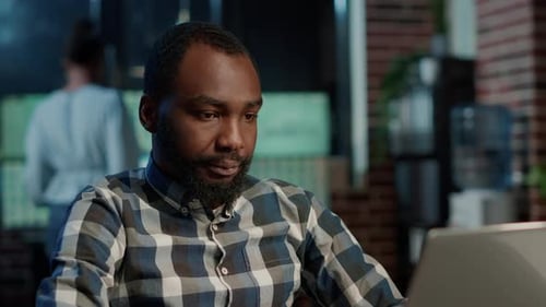 Young Adult Works on Laptop in Office