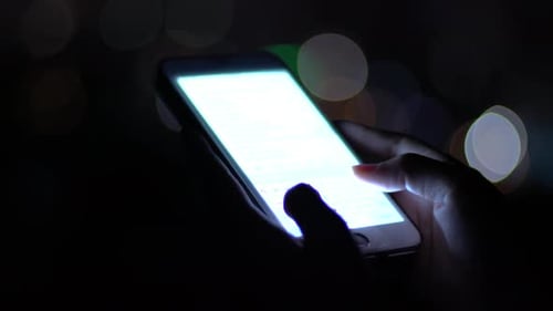 Hands Using Bright Smartphone at Night, Close Up