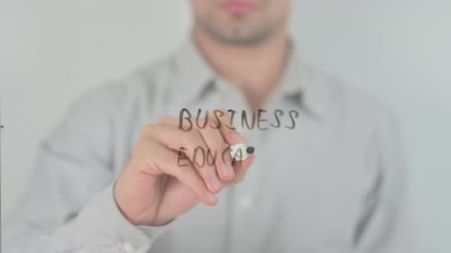 Man Writes Business Education on Glass Surface