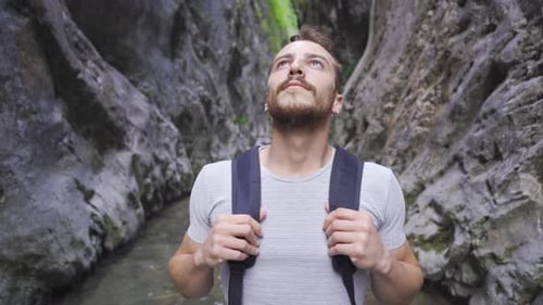 Young man admiring the canyon. There is a creek.