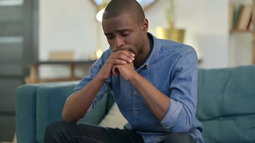 Stressed Young Adult Sitting on Couch at Home