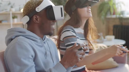 Excited Couple Using VR Headsets Playing Video Games