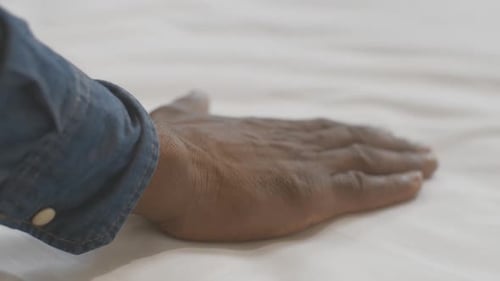 Camera Follows Young African American Male Hand Touching White Bedding. Unrecognizable Tourist