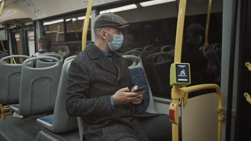 Man Rides Public Transit Looking at Phone