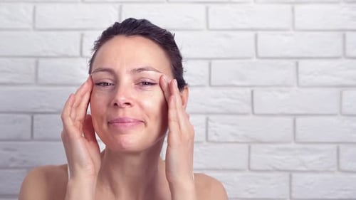 Woman Applies Eye Patches for Beauty Treatment