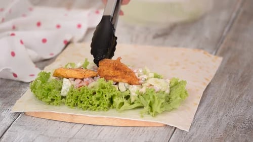 Woman is Cooking Pita Bread Roll with Chicken and Vegetables