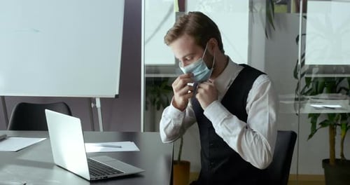 Professional Using Laptop Wearing Mask in Office