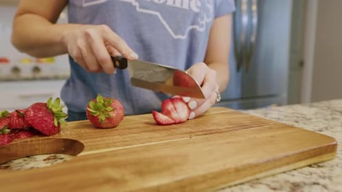 Woman Cutting Fresh Strawberries on Cutting Board