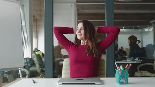 Woman Relaxes at Desk After Closing Laptop