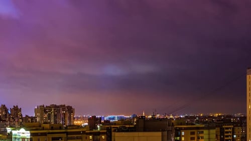 Timelapse - Wolken bewegen sich schnell am Nachthimmel über der Großstadt. Lila, Rosa, Blau der Farben des Himmels