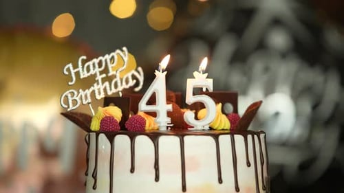 Celebratory Birthday Cake with Number Candles Being Blown Out
