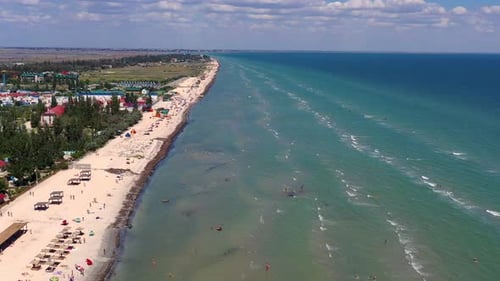 Beautiful flight in summer over the beach. People are resting near the sea.