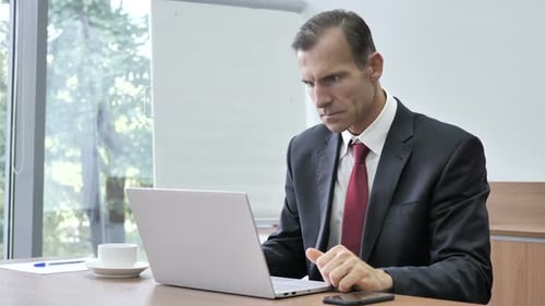 Man Works at Laptop, Expresses Shock