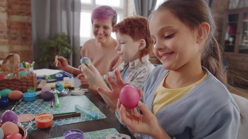 Little Girl Applying Paint to Easter Egg with Finger