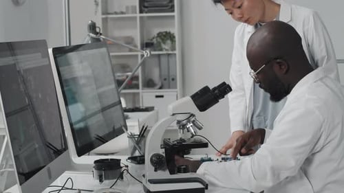 Scientists Working With Microscope in Modern Lab