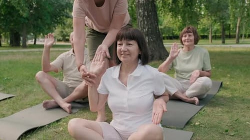 Three Seniors Practicing Yoga with Coach Help
