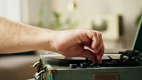 Hand Adjusting Vintage Record Player Indoors