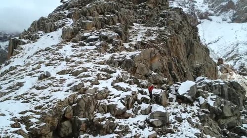 Hiker Trekking Along Snowy Mountain Ridge