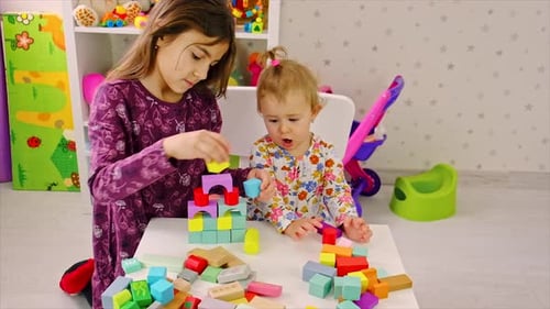 Two Children Playing with Colorful Wooden Blocks Indoors
