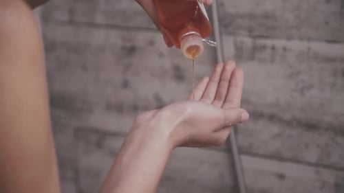 Pouring Liquid Soap into Hand in Bathroom