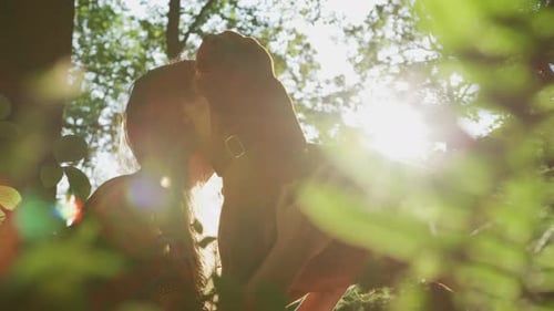 Woman Embracing Dog Affectionately in Sunny Forest